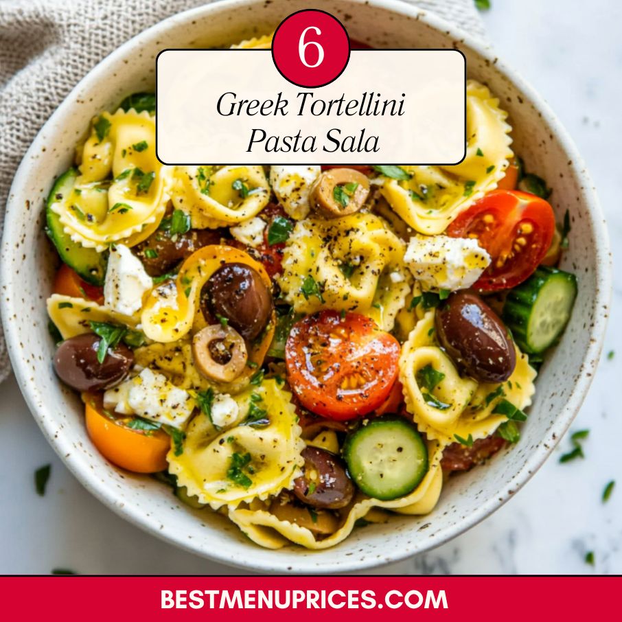 Colorful Greek tortellini pasta salad with cherry tomatoes, cucumber, olives, feta cheese, and herbs